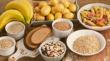 Spread of carbohydrate foods including bananas, lentils, pasta, oranges, and rice - Kaizen Naturals