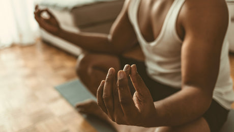 Man meditating on living room floor