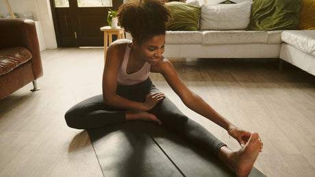 Woman stretching on floor - Kaizen Naturals